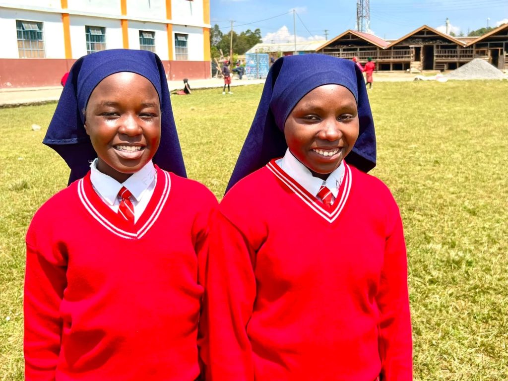 Two St Barnabas pupils in red school sweaters